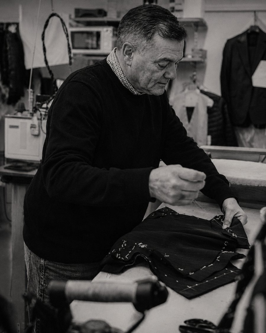 Master tailor hand-finishing a bespoke wool suit jacket at House of Lannoy